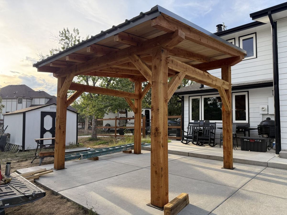 Timber frame pavilion attached to the back patio of a family home in Arvada