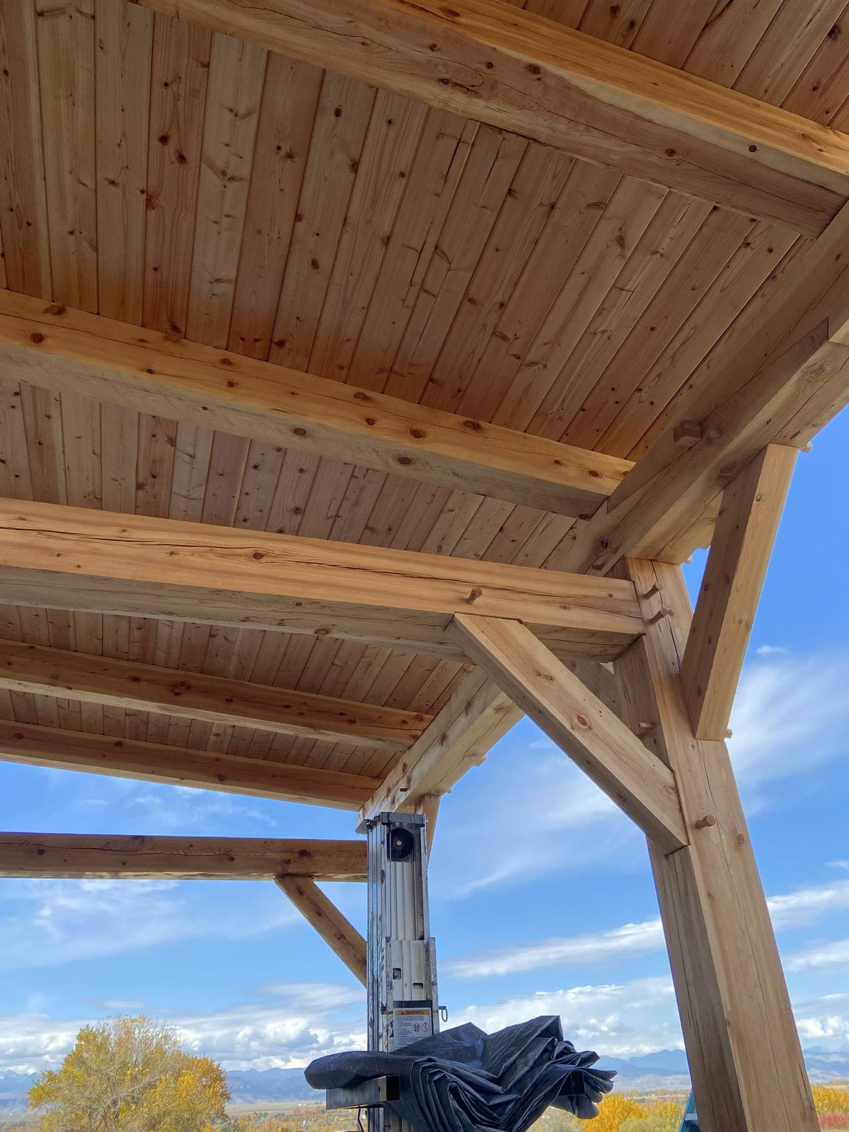 Underside of a finished pavilion roof showing tongue-and-groove decking over hand-cut timber framing