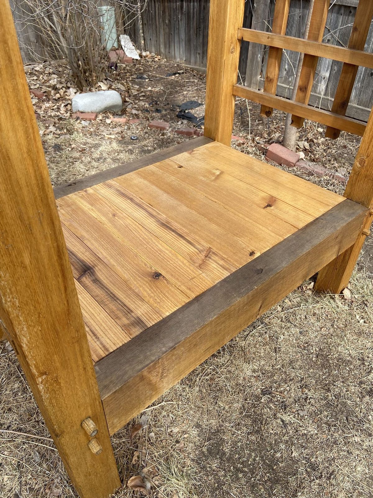 Close view of a solid cedar bench top and the timber frame supporting it