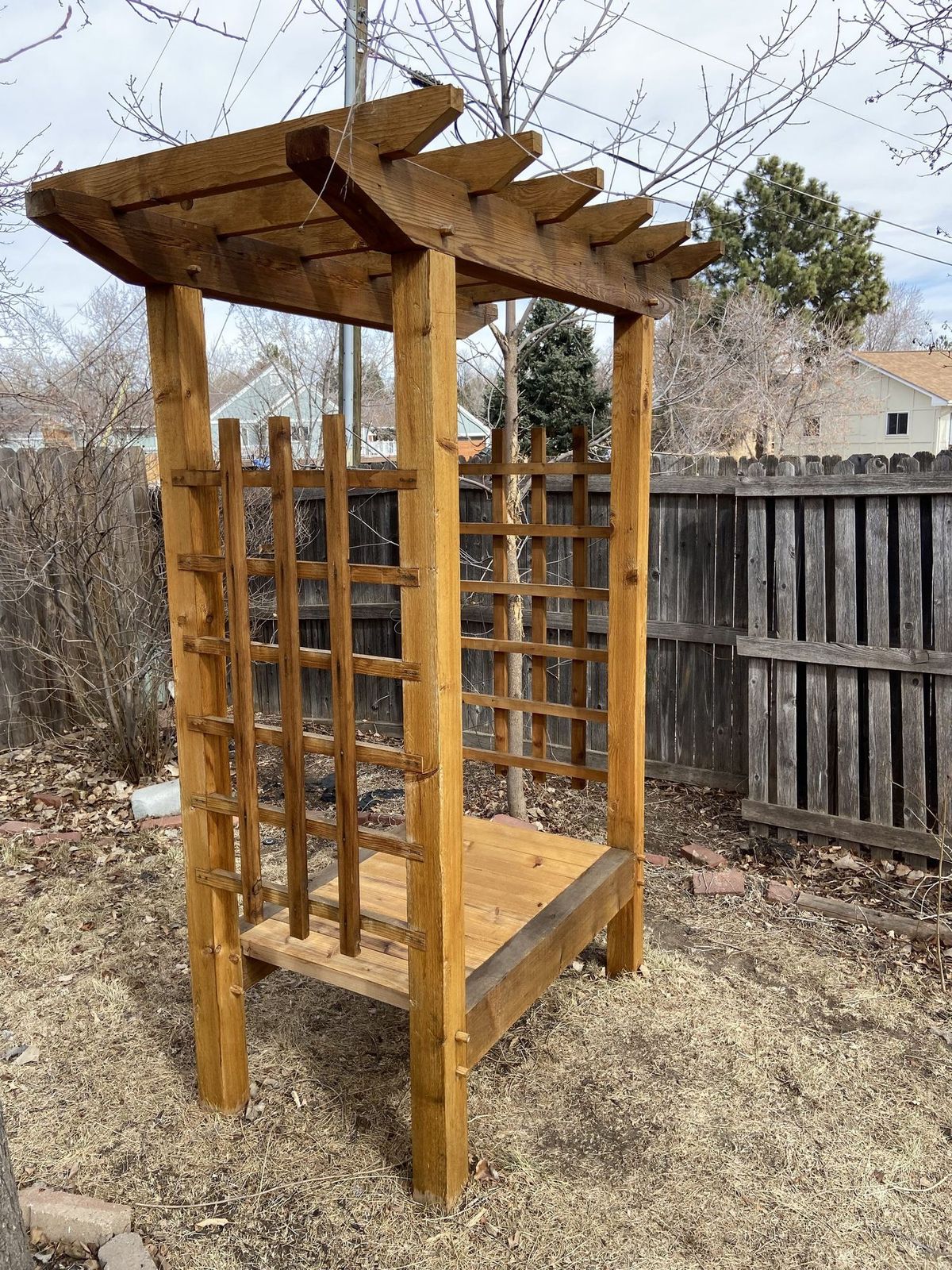 Cedar trellis and bench from the side, with the lattice set into the posts